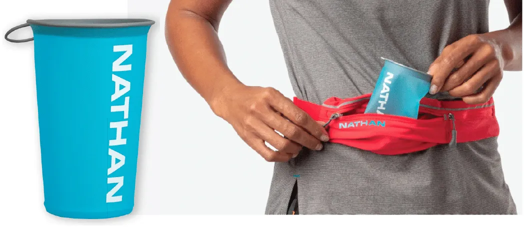 Nathan-reusable cup-lifestyle image of the foldable Nathan cup next to a person folding the cup into their waistbag