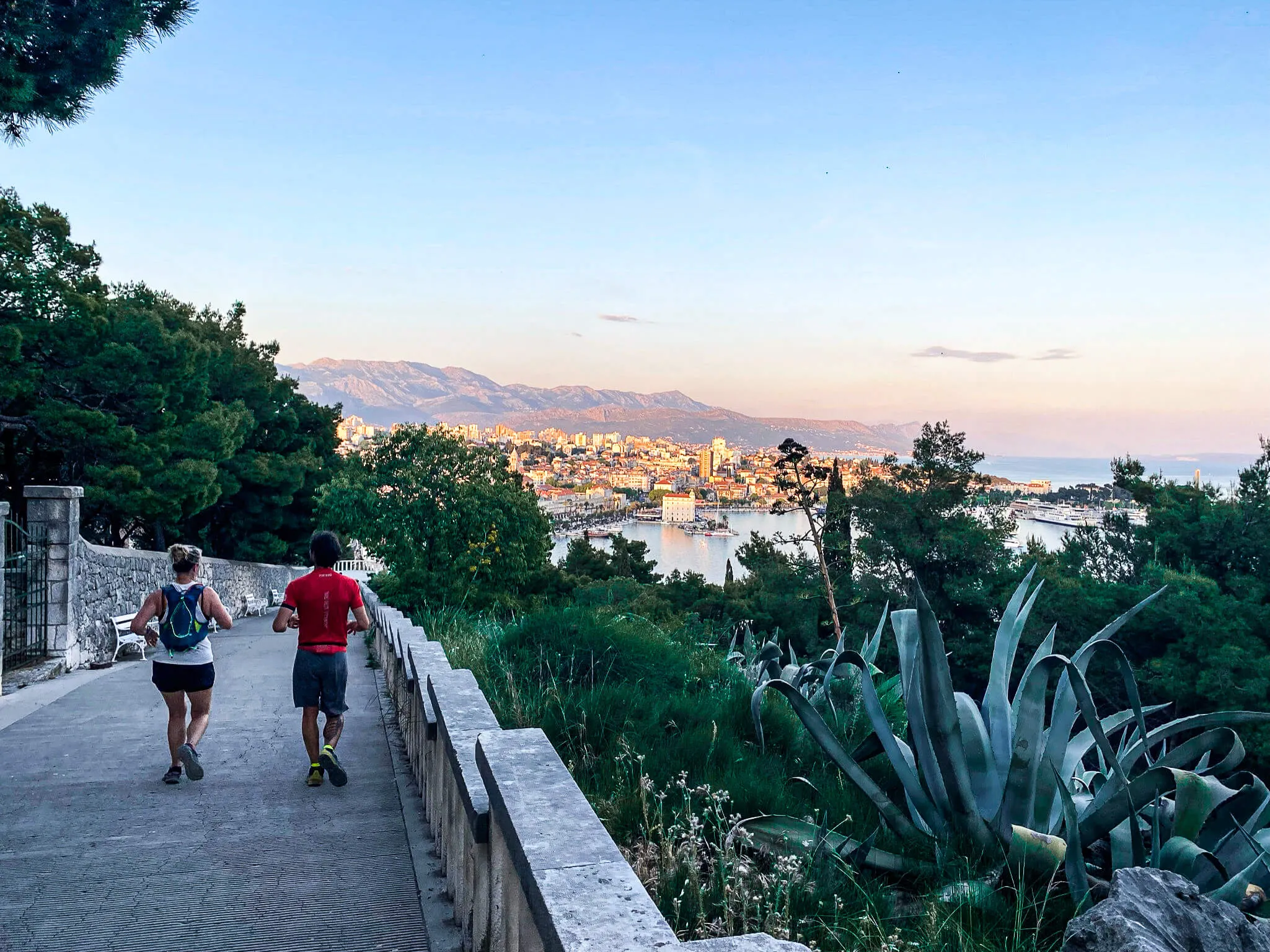Croatia-Split - 10 of 93 Two Global Adventures runners descending a walkway with a sunset view of Croatia on their running trip