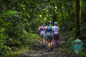 A group running through a shady, lush trail