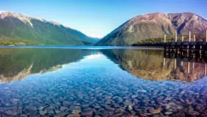 The glasslike waters of Lake Rotoiti, where we will run on our running trip new Zealand Global Adventure