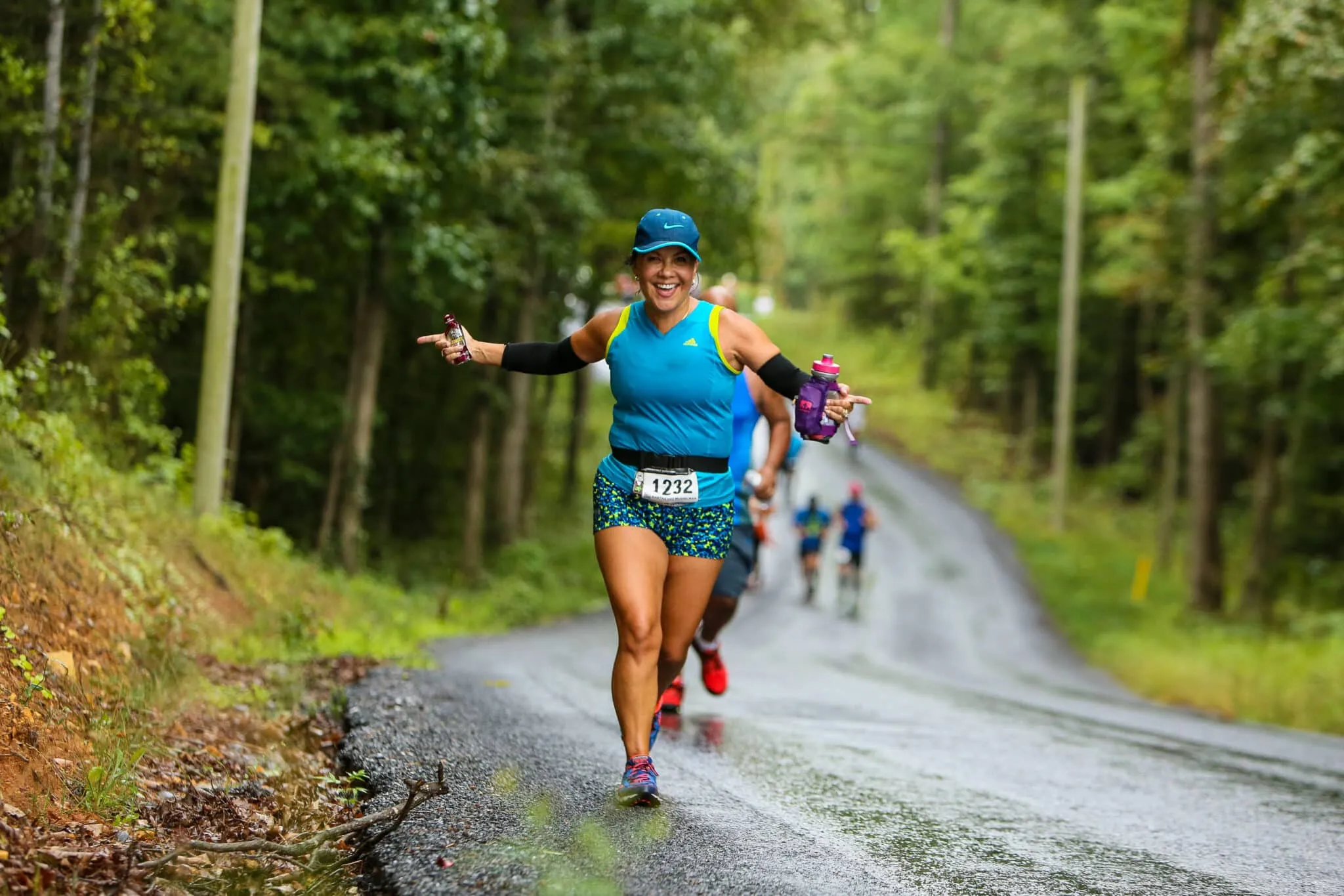 Shenandoah 20171232-2 A woman grins and poses for the camera as she sprints towards the Vacation RacesShenandoah Half Marathon finish line